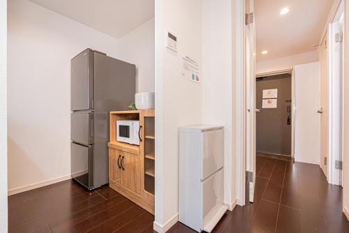 a kitchen with a refrigerator and a microwave at Wasabi Sky Oshiage 押上駅徒歩アパート in Tokyo