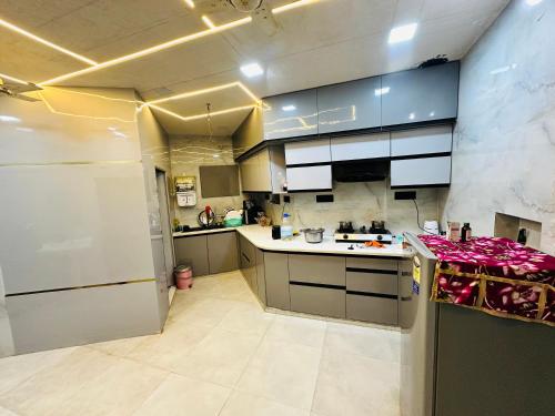 a kitchen with blue cabinets and a white refrigerator at Taj Castle A Boutique Homestay in Agra