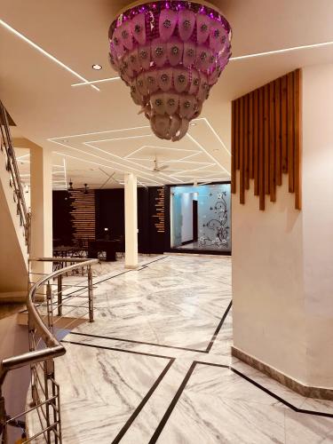 a lobby with a large purple chandelier hanging from the ceiling at Taj Castle A Boutique Homestay in Agra