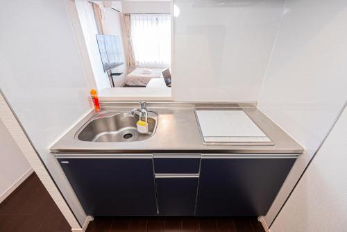 a sink in a small room with a mirror at Wasabi Sky Oshiage 押上駅徒歩アパート in Tokyo