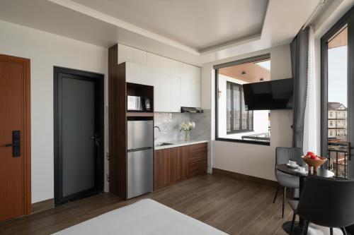 a room with a bed and a table and a kitchen at Anteaus Hotel Đà Lạt in Da Thien