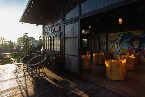a restaurant with wooden chairs and a building at Olala Glamping Bảo Lộc in Bao Loc