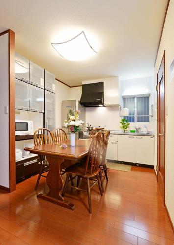 a kitchen with a wooden table and chairs in it at Shalom 鶴橋 地铁口徒步10秒钟可以到民宿徒步9分钟到上本町位置绝佳 in Osaka