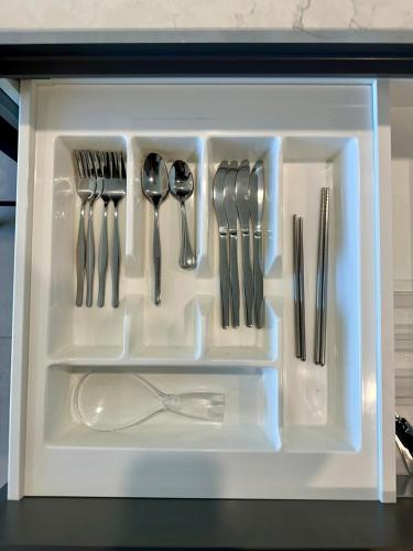 a plastic container filled with utensils in a drawer at New & Rated Free Spa, Gym, Parking & More in Belconnen