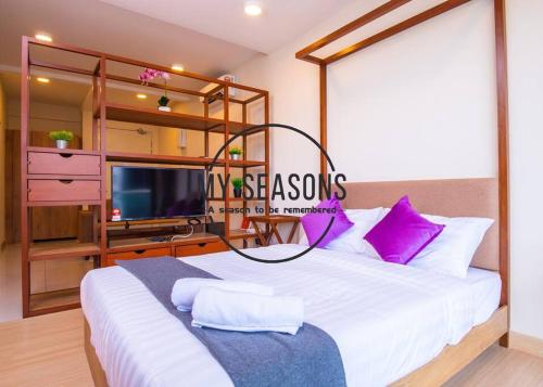 a bedroom with a large white bed with purple pillows at Timurbay by My Seasons in Kuantan