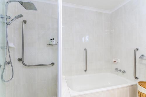 a bathroom with a shower and a white bath tub at Keith's Place, 1 of the 3 most popular units on Bribie in Bongaree