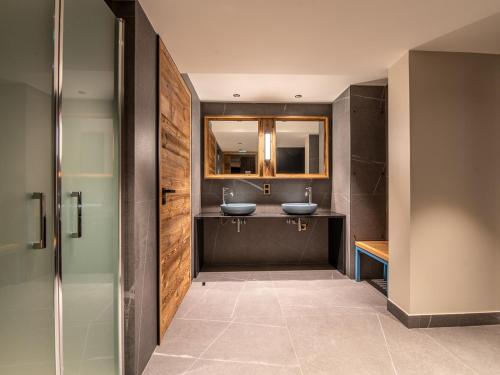 a bathroom with two sinks and two mirrors at Appartement luxe 3 chambres avec spa et accès direct aux pistes - FR-1-613-51 in Les Allues
