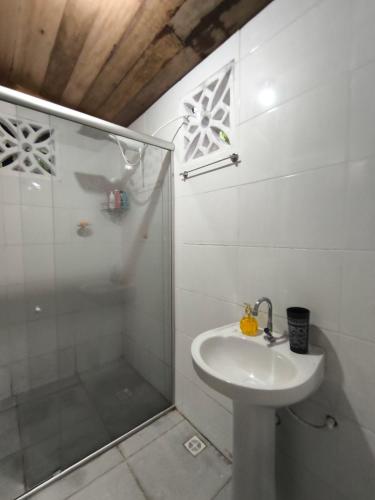 a white bathroom with a shower and a sink at Pousada CCPC in Belém
