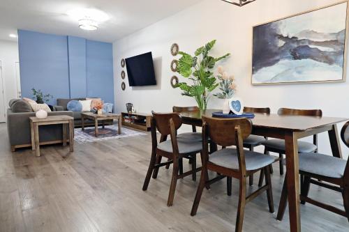 a living room with a table and chairs and a couch at Beautiful 3 King Beds,Garage,Airport,Disney+ in Edmonton