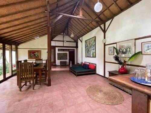 a living room with a table and a dining room at Temuku Pupuan Farmstay in Padangan