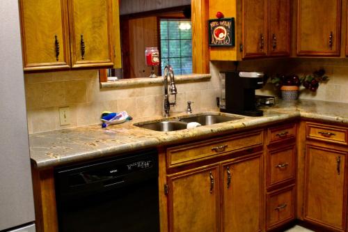 a kitchen with wooden cabinets and a sink at Toledo Bend Home 1 in Hemphill