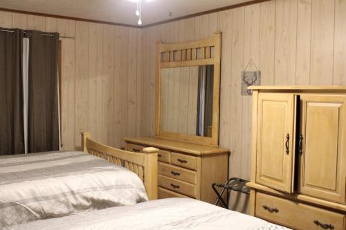 a bedroom with two beds and a dresser and a mirror at Toledo Bend Home 1 in Hemphill