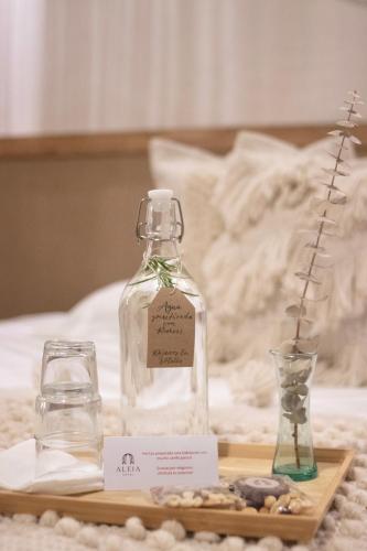 a bottle on a tray with a drink and a glass at Hotel ALEIA Centro in Taxco de Alarcón