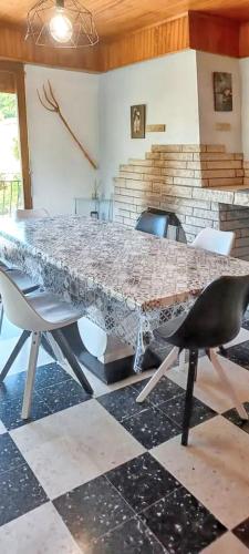 - une table et des chaises dans le salon avec une table en pierre dans l'établissement Appartement cosy Cornimont + terrasse, à Cornimont