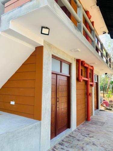 a house with a red door and a staircase at Resolve Garden Hotel in Dodangoda