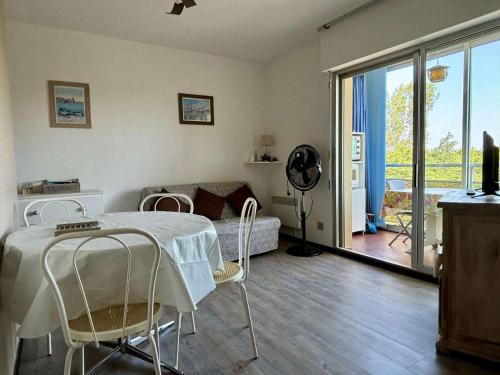 une chambre avec une table et des chaises ainsi qu'un salon dans l'établissement Argelès : T2 proche plage, parking, TV, lave-vaisselle - FR-1-225-823, à Argelès-sur-Mer