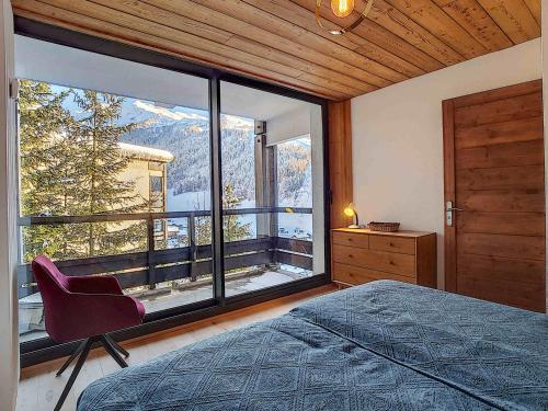 une chambre avec un lit et une grande fenêtre dans l'établissement Appartement cosy pour 6 pers., 3 pièces, La Clusaz - FR-1-818-4, à La Clusaz