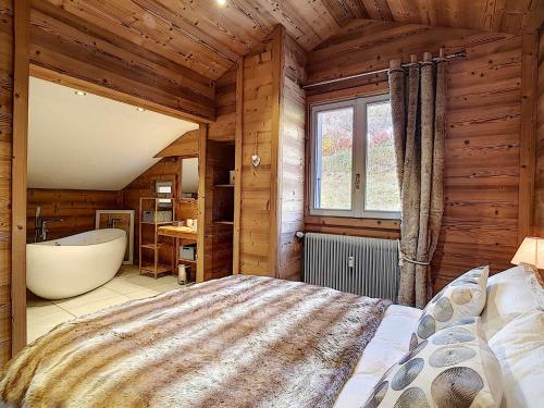 une chambre avec un grand lit et une baignoire dans l'établissement La Clusaz : Appartement 6 pers, Mezzanine, Terrasse Sud - FR-1-818-7, à La Clusaz