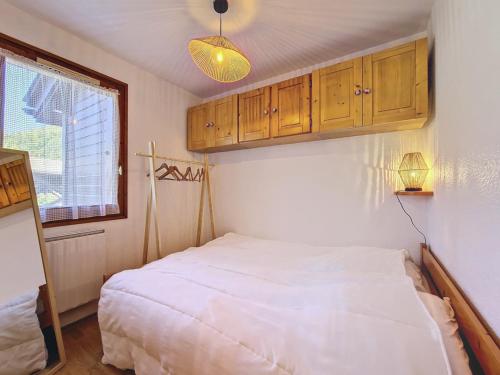 - une chambre avec un lit blanc et des placards en bois dans l'établissement Appartement cosy La Clusaz - 4 pers., parking, balcon, 2* - FR-1-818-17, à La Clusaz