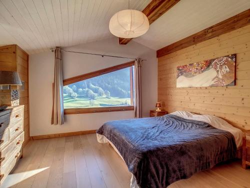 une chambre avec un lit et une grande fenêtre dans l'établissement Duplex cosy 6 pers, 2 ch, garage, La Clusaz - FR-1-818-20, à La Clusaz