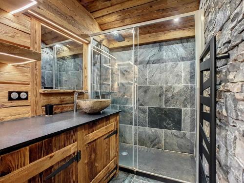 La salle de bains est pourvue d'une douche et d'un mur en pierre. dans l'établissement Duplex cosy 6 pers, 2 ch, garage, La Clusaz - FR-1-818-20, à La Clusaz