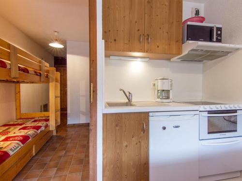 une petite cuisine avec un évier et un micro-ondes dans l'établissement Appartement confortable à La Clusaz - 6 pers, Wifi, parking, proche pistes - FR-1-818-14, à La Clusaz