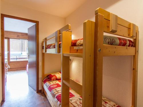 Cette chambre comprend 2 lits superposés et une porte. dans l'établissement Appartement confortable à La Clusaz - 6 pers, Wifi, parking, proche pistes - FR-1-818-14, à La Clusaz