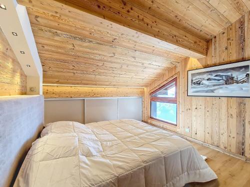a bedroom with a bed in a wooden room at Appartement 8 pers rénové, 2 ch, accepte animaux, garage - La Clusaz - FR-1-818-21 in La Clusaz