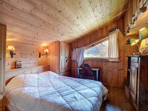 une chambre avec un lit dans une cabane en bois dans l'établissement La Clusaz - Appartement familial pour 6 pers avec 2 chambres et balcon - FR-1-818-16, à La Clusaz