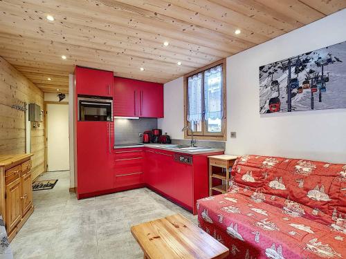 un salon avec un canapé rouge et une cuisine dans l'établissement Appartement cosy à La Clusaz avec balcon, 4 pers, Wifi inclus - FR-1-818-25, à La Clusaz