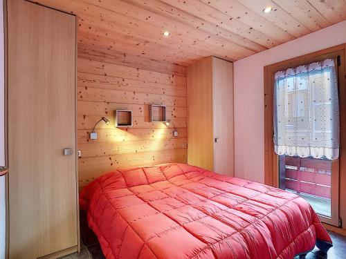 Cette chambre en bois comprend un lit rouge. dans l'établissement Appartement cosy à La Clusaz avec balcon, 4 pers, Wifi inclus - FR-1-818-25, à La Clusaz