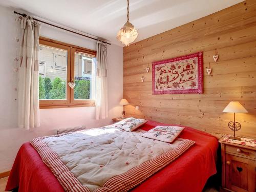une chambre avec un grand lit avec une couverture rouge dans l'établissement Charmant appartement à La Clusaz avec terrasse, parking et wifi - FR-1-818-58, à La Clusaz