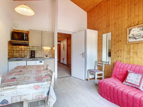 une cuisine et un salon avec un canapé rose dans l'établissement Charmant appart 4 pers, balcon sud, garage, WiFi, La Clusaz - FR-1-818-67, à La Clusaz