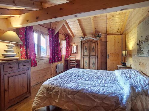 a bedroom with a bed in a log cabin at Chalet haut de gamme 8 pers à La Clusaz avec Wifi et parking - FR-1-818-74 in La Clusaz
