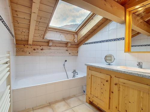 a bathroom with a tub and a sink and a window at Chalet haut de gamme 8 pers à La Clusaz avec Wifi et parking - FR-1-818-74 in La Clusaz