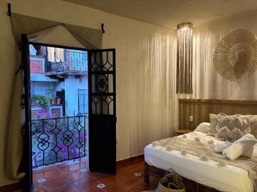 a bedroom with a bed and a glass door at Hotel ALEIA Centro in Taxco de Alarcón