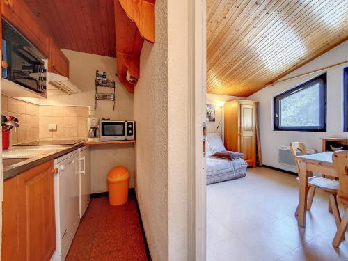 une petite cuisine avec une table et un canapé dans l'établissement Appartement cosy pour 4 avec WiFi, animaux admis - FR-1-818-81, à La Clusaz
