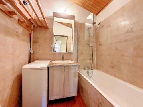 une salle de bain avec un lavabo et une baignoire dans l'établissement Appartement cosy pour 4 avec WiFi, animaux admis - FR-1-818-81, à La Clusaz