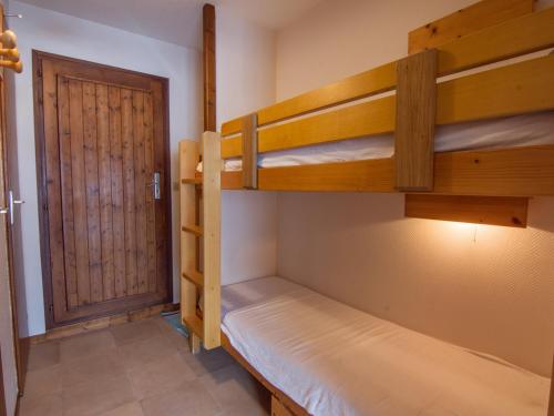 Cette chambre comprend 2 lits superposés et une porte. dans l'établissement Confortable studio à La Clusaz, 4 pers, WIFI, balcon sud - FR-1-818-101, à La Clusaz