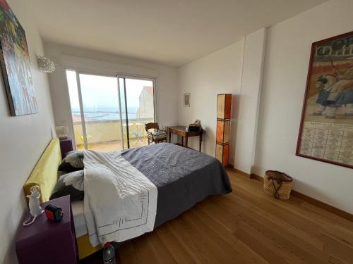 une chambre avec un lit et une grande fenêtre dans l'établissement Superbe duplex climatisé avec vue mer, 2 chambres, WIFI à Sète - FR-1-338-593, à Sète