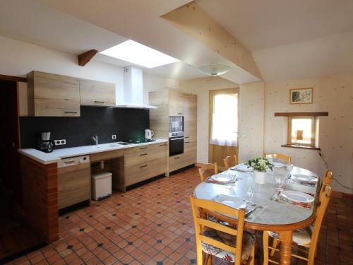 une cuisine avec une table et des chaises dans une pièce dans l'établissement Gîte Anjou familial avec cheminée, climatisation, WIFI - FR-1-622-95, à Baugé