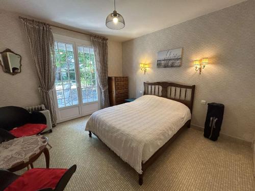 une chambre avec un lit, une chaise et une fenêtre dans l'établissement Maison cosy près plage avec jardin et parking - FR-1-224C-332, à Saint-Jean-de-Monts