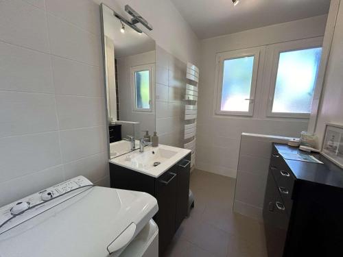 une salle de bain blanche avec un lavabo et un miroir dans l'établissement Maison cosy près plage avec jardin et parking - FR-1-224C-332, à Saint-Jean-de-Monts