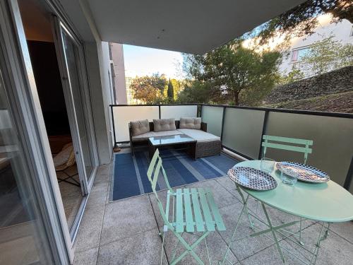 un patio avec une table et des chaises sur un balcon dans l'établissement Confort moderne à Sète : 2 pièces, parking, WIFI - FR-1-338-594, à Sète