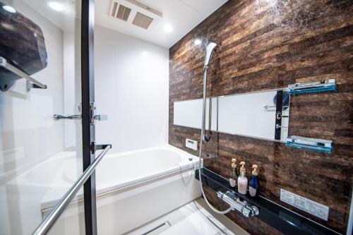 a bathroom with a shower and a brick wall at Hotel Naranohamori in Nara