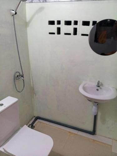 a bathroom with a sink and a toilet at Air Manis Secret Surfcamp in Taluk Batung
