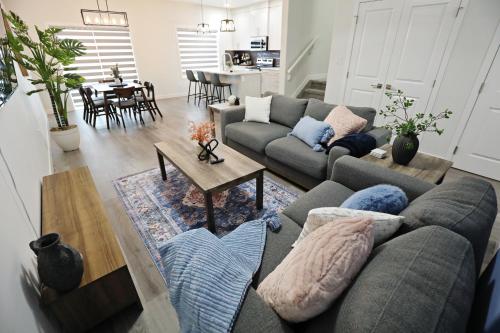 a living room with a couch and a table at Beautiful Home With 4 King Beds,Airport,Disney+ in Edmonton