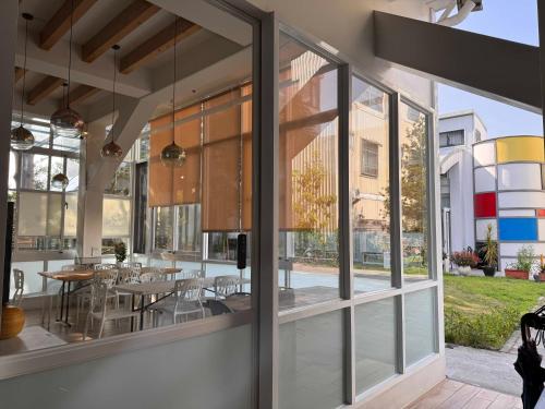 a room with large windows and a table and chairs at REST Book & Bed in Puli