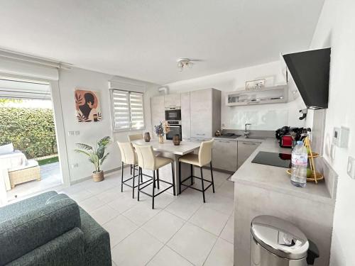 une cuisine et un salon avec une table et des chaises dans l'établissement Mazet 3 pièces avec jardin, climatisation et parking au Muy - FR-1-226-554, au Muy