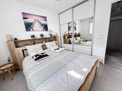une chambre avec un grand lit et un miroir dans l'établissement Mazet 3 pièces avec jardin, climatisation et parking au Muy - FR-1-226-554, au Muy